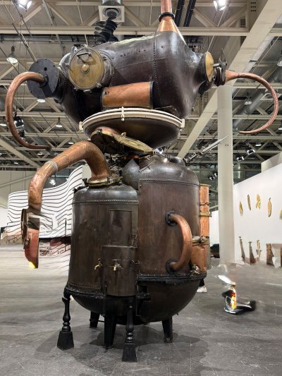 A large-scale sculpture made up of various industrial machines from a perfume factory.