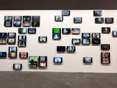 A couple of dozen small screens installed at different intervals on a wall.