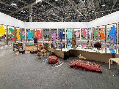 A mirror table in the shape of the Mediterranean Sea stands before several wall-hung mirrors that read 'respect' in various languages.