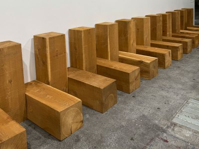 Alternating vertical and horizontal beams of wood against a white wall.