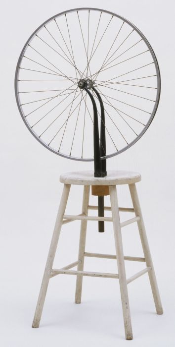 A bicycle wheel mounted to a stool.