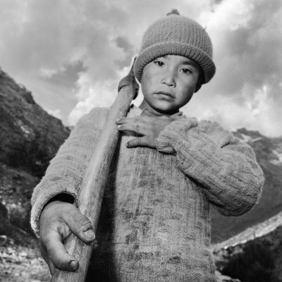 A child with an axe swung over one shoulder.