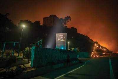 LOS ANGELES, CALIFORNIA - JANUARY 8: Flames from the Palisades Fire reach the grounds of the Getty Villa Museum on the Pacific Coast Highway amid a powerful windstorm on January 8, 2025 in Los Angeles, California.  The fast-moving wildfire has grown to more than 2900-acres and is threatening homes in the coastal neighborhood amid intense Santa Ana Winds and dry conditions in Southern California. (Photo by Apu Gomes/Getty Images)