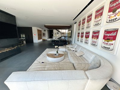 View of the living room of an upscale home, with works by Andy Warhol hanging on the walls. 