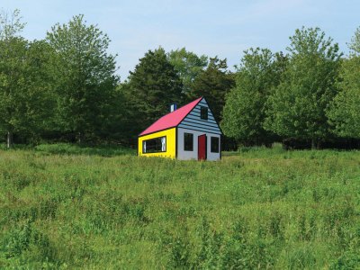 A Pop sculptural installation of a house in a meadow.