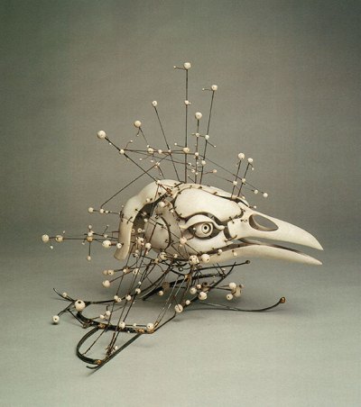 A sculpture that resembles the skull and beak of a bird with various orbs coming out of it.