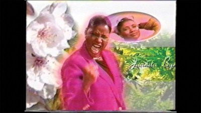 A video still of a Black woman singing.