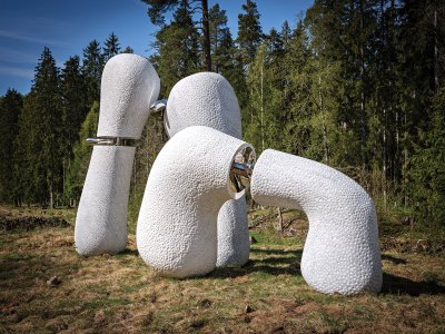 A white and metal sculpture in nature.