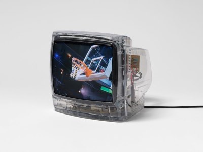 A small TV showing a video, with a still of a basketball hoop at a game.