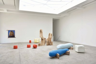 View of a gallery showing various sculptural elements arranged on the floor.