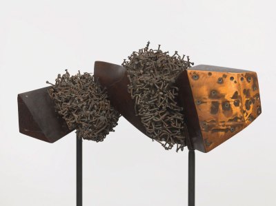 A metal sculpture made of various components including hundreds of bent nails.