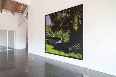 A landscape painting hangs on a museum wall.