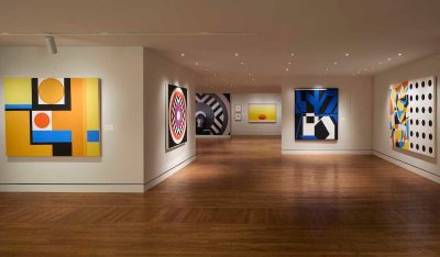 A gallery hung with abstract paintings.