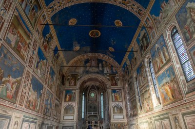 A chapel with a blue, domed ceiling and paintings on its walls.