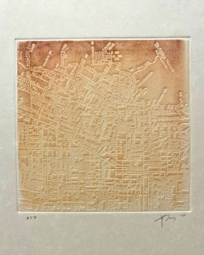 An embossed print showing a map of Altadena that has been rubbed with ochre-shaded soil.