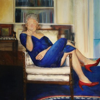 A painting of a smiling man in a blue dress and red heels sitting in a chair cross-legged, smiling, and pointing one finger toward the viewer.
