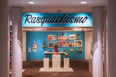 View of a museum exhibition with the word 'Rasquachismo' painted on a sign.