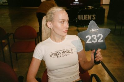 A woman in a white T-shirt holding a star-shaped paddle.