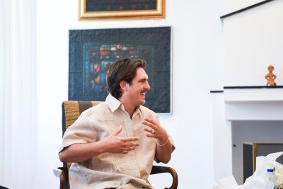 A smiling man in a chair.