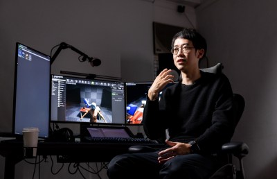 Portrait of Li Yi-Fan in his studio in front of several computer monitors.