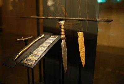 Image of King Tut's Dagger in the foreground with other artifacts in the background.
