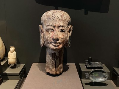 A carved wig stand in the shape of a woman's head.