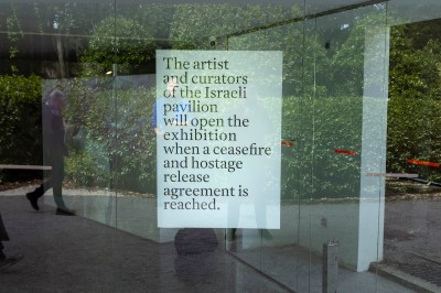 A sign posted to a glass window reading 'The artist and curators of the Israeli pavilion will open the exhibition when a ceasefire and hostage release agreement is reached.'