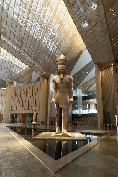 A monumental sculpture of a pharaoh with one foot in front of the other.