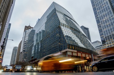 People walk and cars drive outside the glass-fronted James R. Thompson Center in Chicago's Loop on Dec. 15, 2021. (Armando L. Sanchez/Chicago Tribune/Tribune News Service via Getty Images)