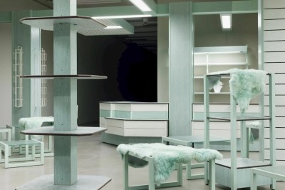 An empty shop interior with some shelves covered in blue-tinged furs.