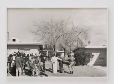 A photograph of soldiers escorting two people away.