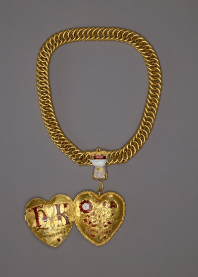 A heart-shaped pendant that is open to show both sides, including the initials 'h' and 'k' connected with a cord and the intertwined rose and pomegranate bushes. They are attached to a gold chain. 